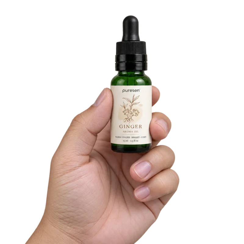 Puresen Ginger 15 ml Aroma Oil held naturally between the fingers of an adult hand