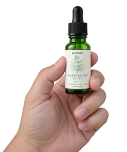 Puresen Peppermint Bliss 15 ml Aroma Oil held naturally between the fingers of an adult hand