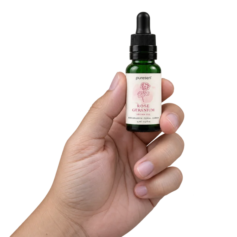 Puresen Rose Geranium 15 ml Aroma Oil held naturally between the fingers of an adult hand