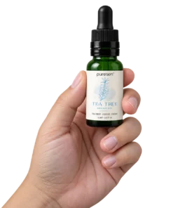 Puresen Tea Tree 15 ml Aroma Oil held naturally between the fingers of an adult hand