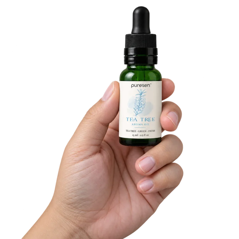 Puresen Tea Tree 15 ml Aroma Oil held naturally between the fingers of an adult hand